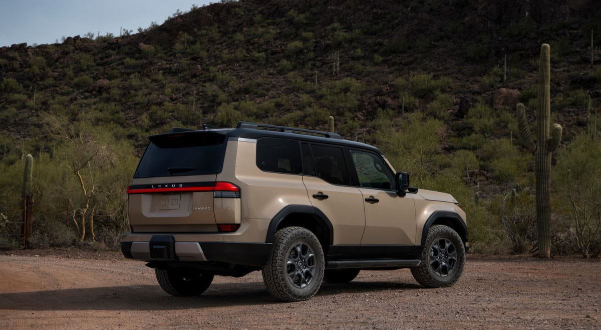 2025 Lexus GX550 Overtrail SUV with 33-inch all-terrain tires, off-road bumpers, and rugged Overtrail design package parked on rocky desert terrain.