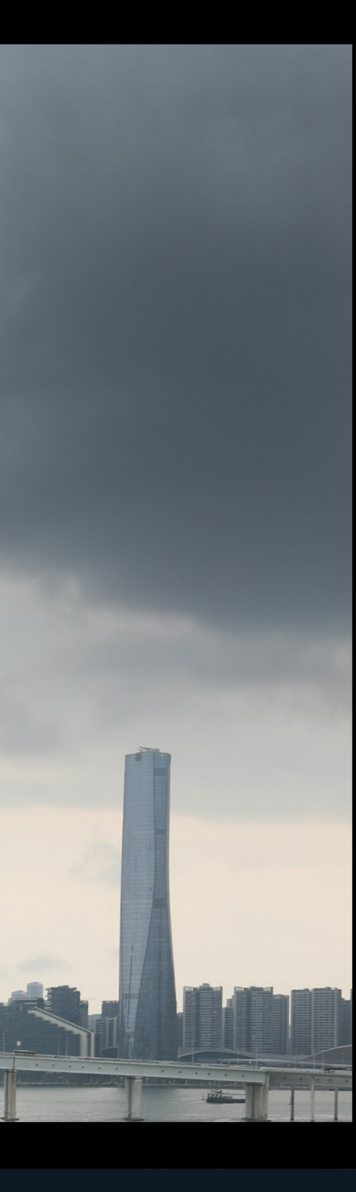 Macau and Guangzhou skyline with a bridge under dramatic storm clouds