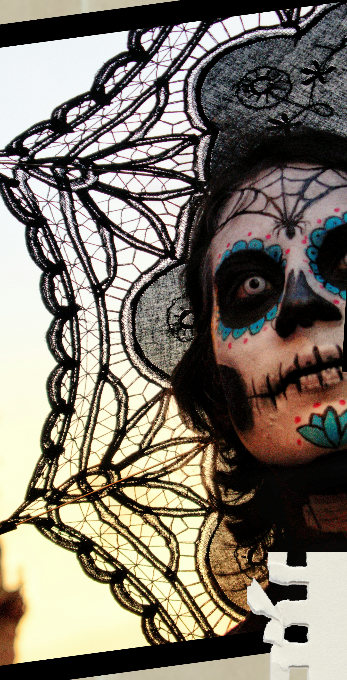 A woman in Catrina face paint and lace headdress at a Day of the Dead parade in Mexico City