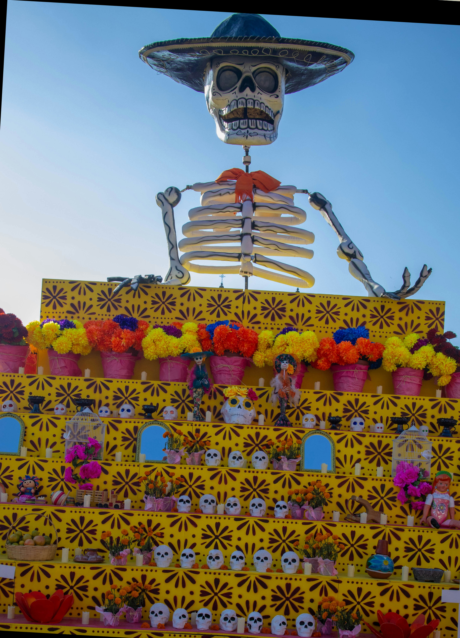 A marigold-covered Day of the Dead ofrenda altar with skeleton figures in Mexico