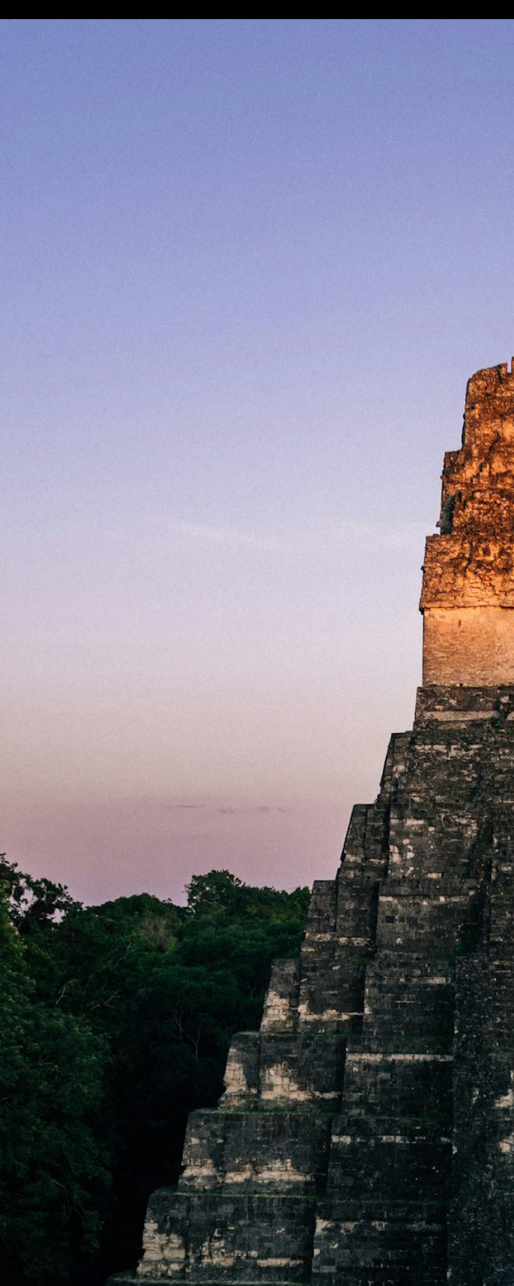 Temple of the Great Jaguar at Tikal rising above the jungle canopy at dusk, Guatemala