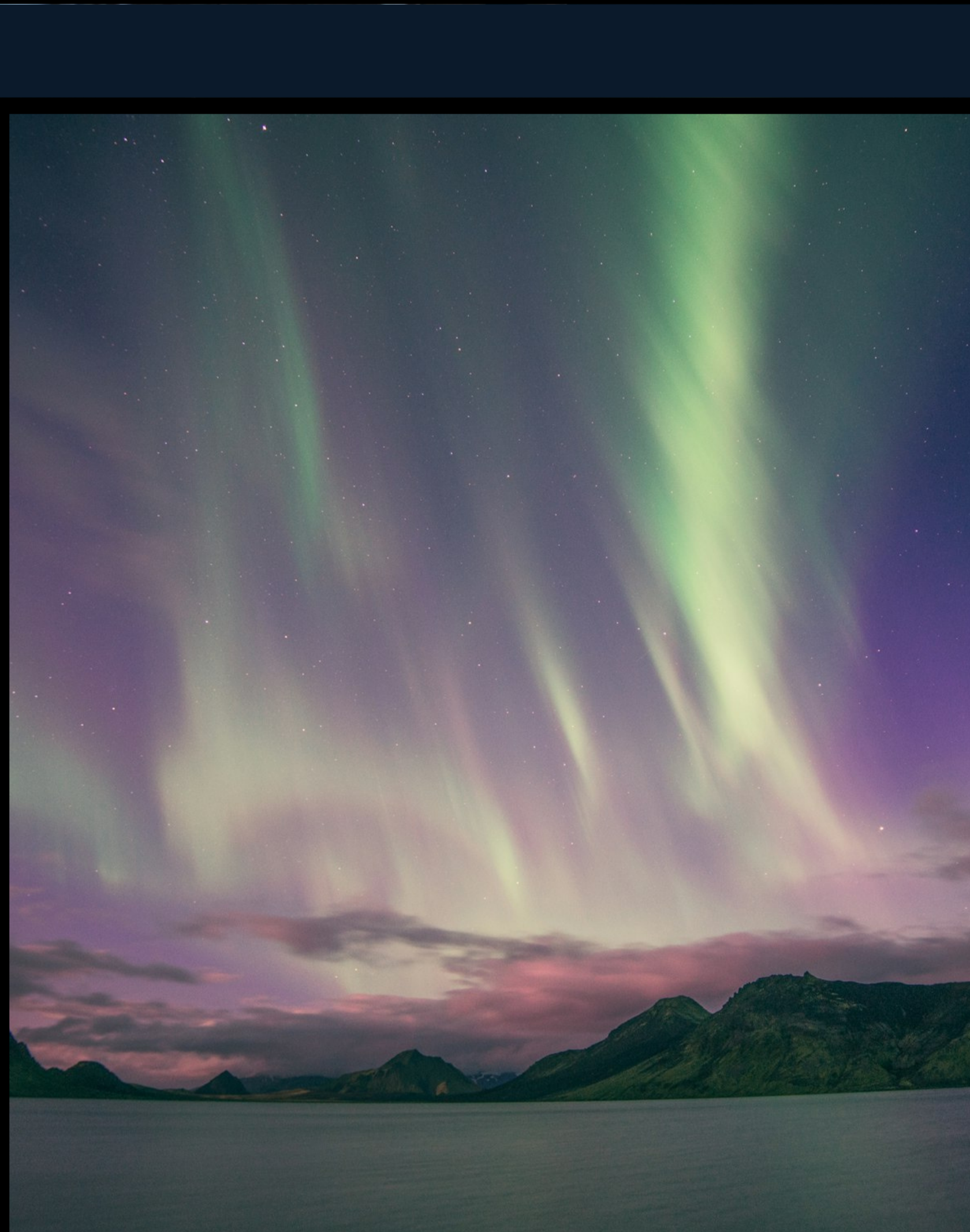 Aurora borealis over a lake and mountains, Iceland