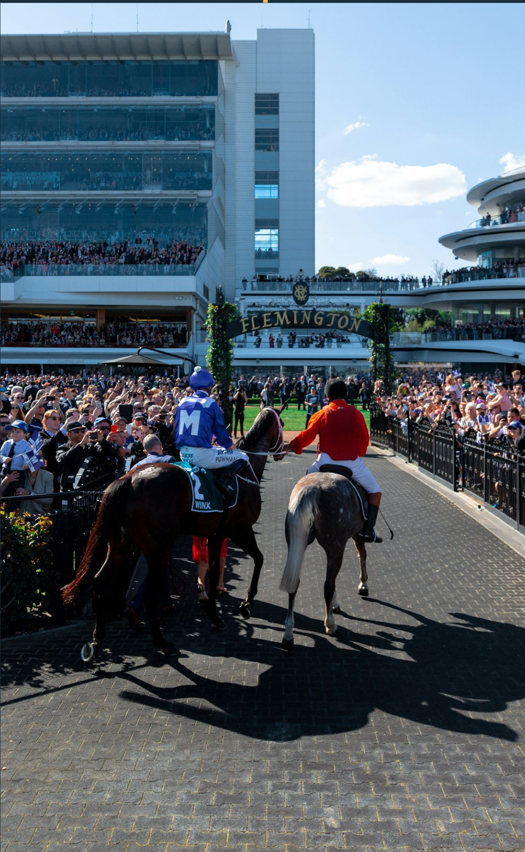 Crowds and horses at the Flemington Racecourse entrance, Melbourne, Australia