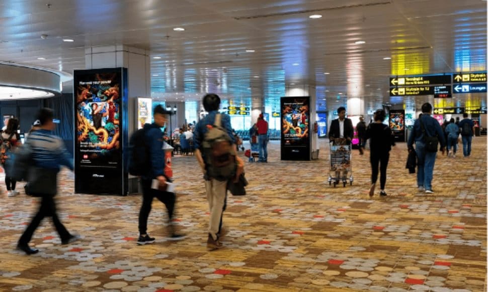 Digital mupi screens in a Changi Airport arrival and departure hall