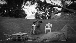 Wooden crates, a plastic chair and a folded-over tent on a hillside.