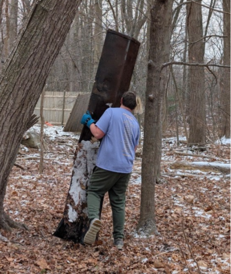 A person carrying a large metal barrel in the woods

AI-generated content may be incorrect.