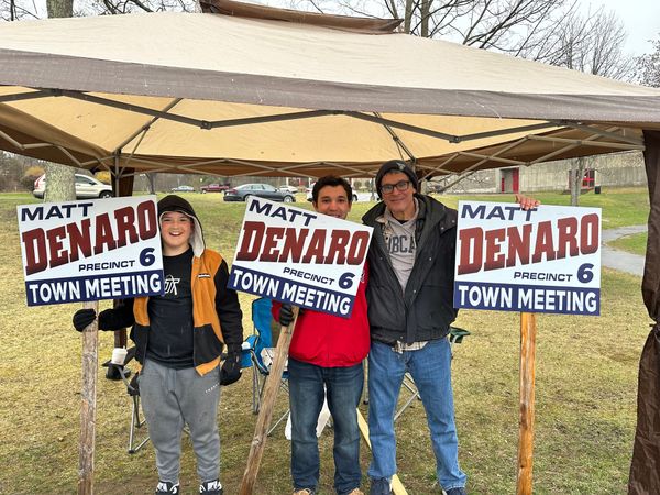 Three people holding signs that say "Matt Denaro Precinct 6 Town Meeting"