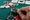 A pair of kings peeks out from a player's hand at a poker table scattered with chips 