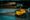 A yellow WALL-E toy robot photographed against a dark blurred background.