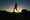 an image of a person running on a hilly terrain with the sun setting in the background 