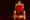 An ornate golden throne with red velvet upholstery and lion armrests against a dark background.