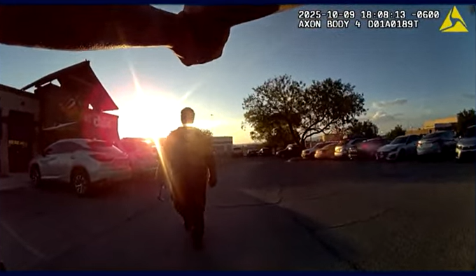 A body-camera still shows a man walking toward an officer in the Chili’s parking lot on Oct. 9, 2025, moments before shots were fired.