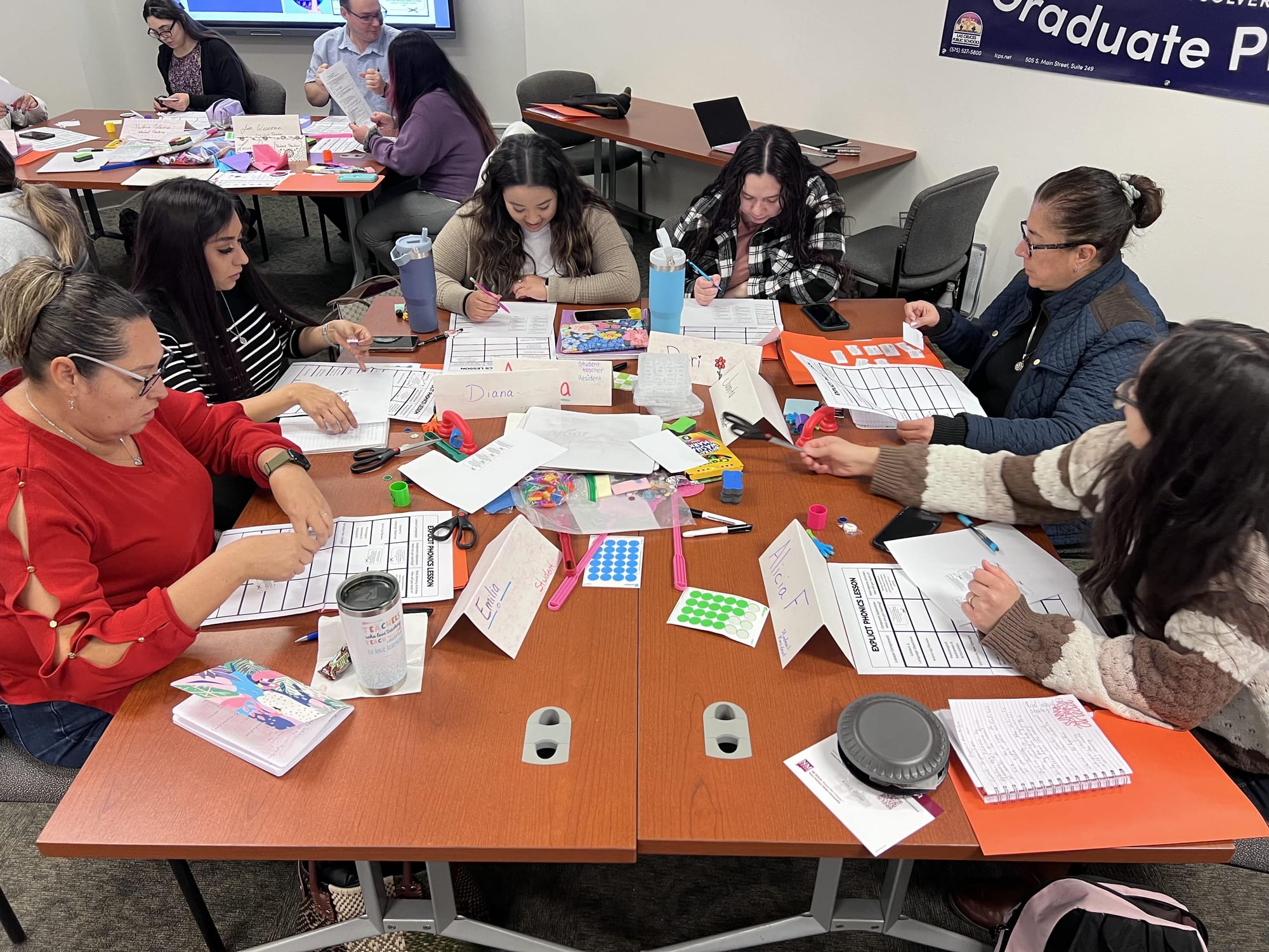 Educators sit around tables during a professional development workshop hosted by NMSU and Las Cruces Public Schools focused on reading science and literacy instruction.