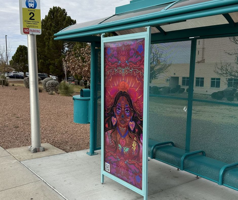 A colorful portrait artwork displayed on a teal bus shelter in Las Cruces for the Art Stop program. The piece shows a woman surrounded by hearts, flowers and vivid patterns along Route 2.