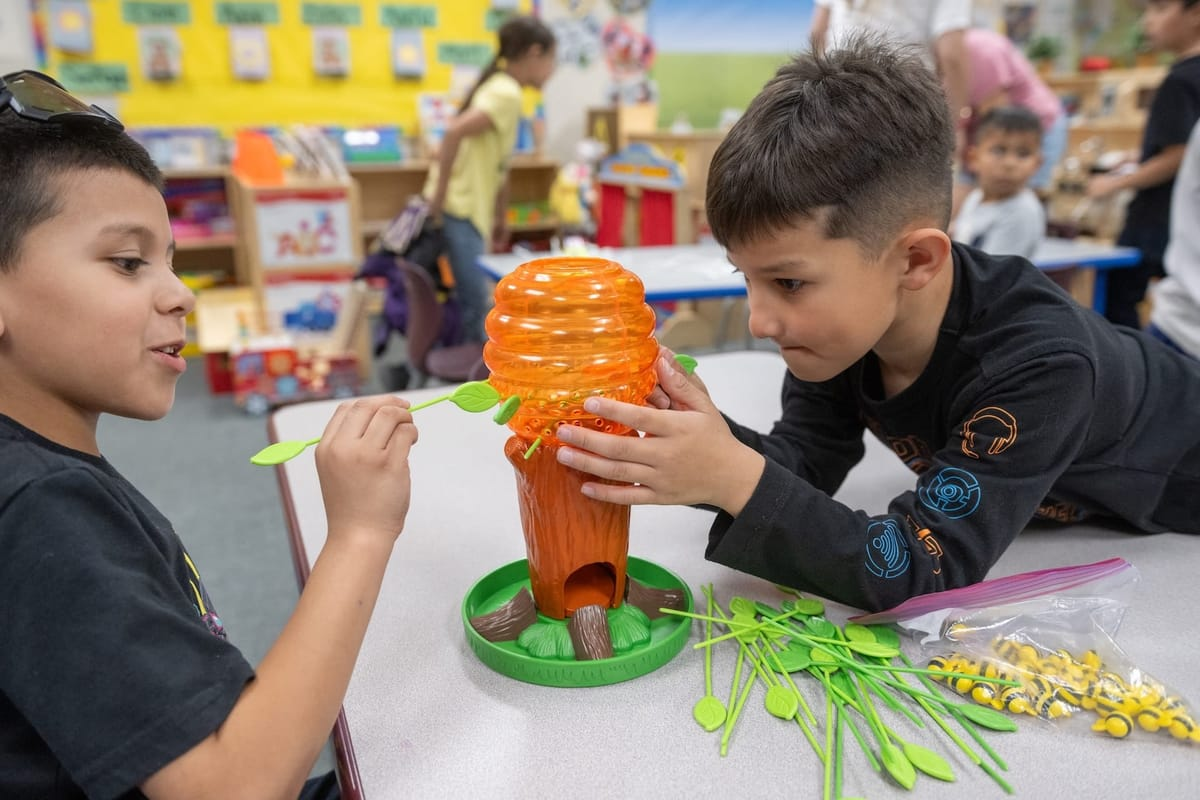 Two elementary school students play an educational game about bees and pollination during an NMSU STEM Outreach Center activity.