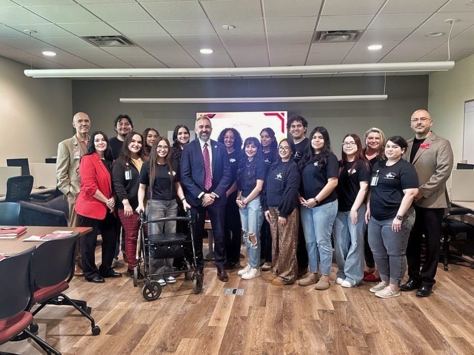 Attorney General Raúl Torrez stands with TRIO students and staff inside a New Mexico Junior College classroom during a group photo in Hobbs.