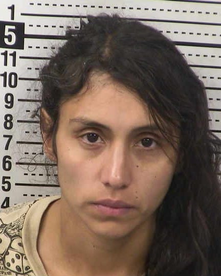 Booking photo of Alma Varela Vitela standing in front of a height chart at a police facility.