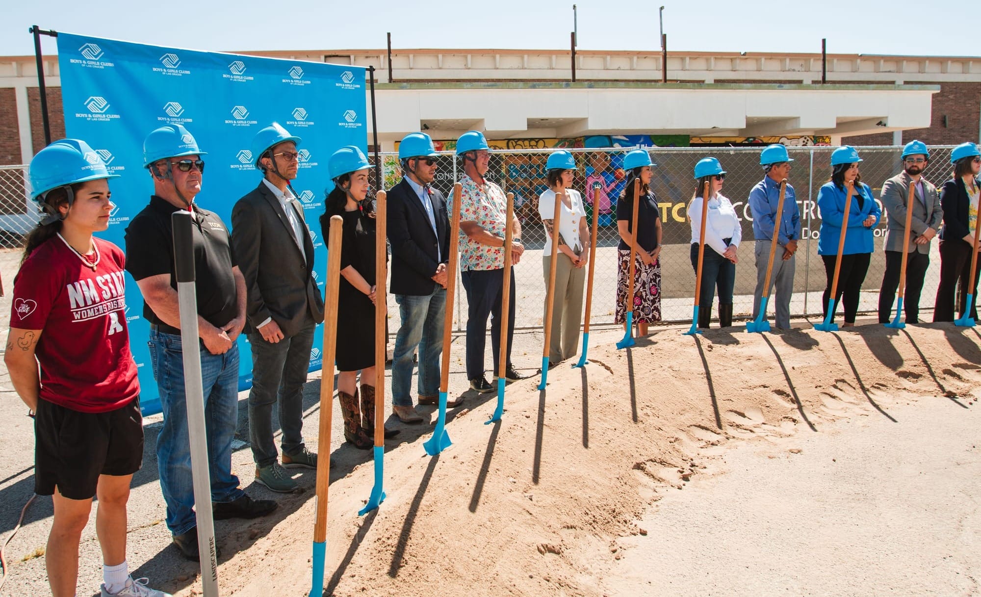 Community members wearing hard hats stand with shovels at the Boys & Girls Club of Las Cruces groundbreaking ceremony.