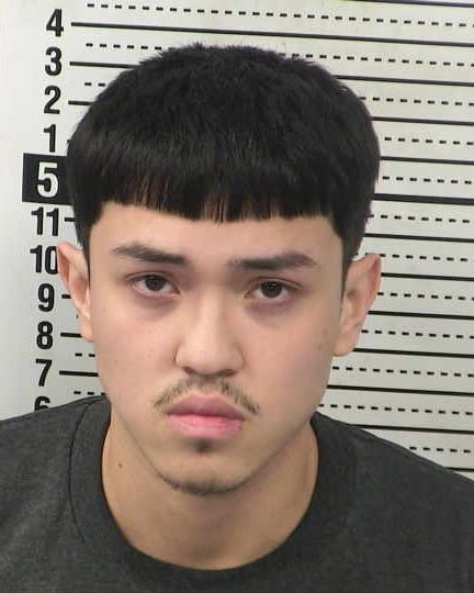 Booking photo of Brian Peña Trevino against a height chart background.