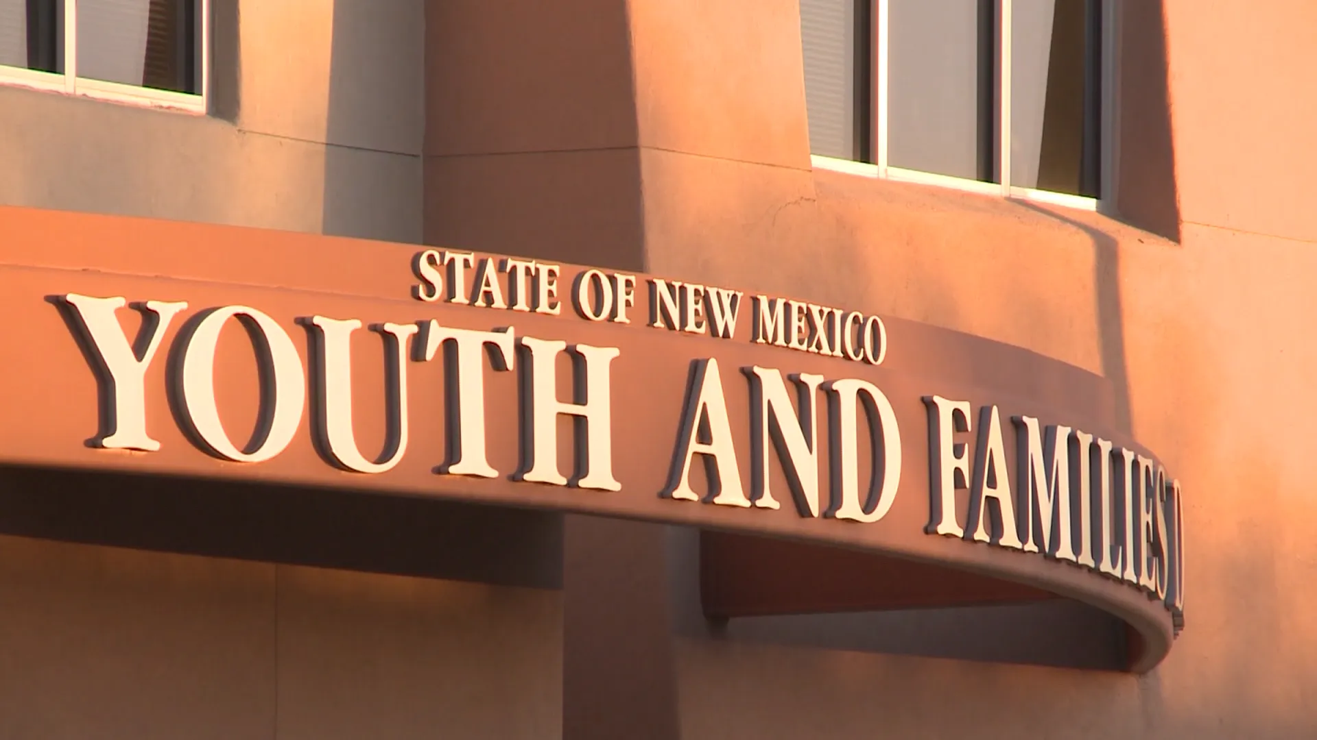Sign reading “State of New Mexico Children, Youth and Families Department” on the exterior of a government building.