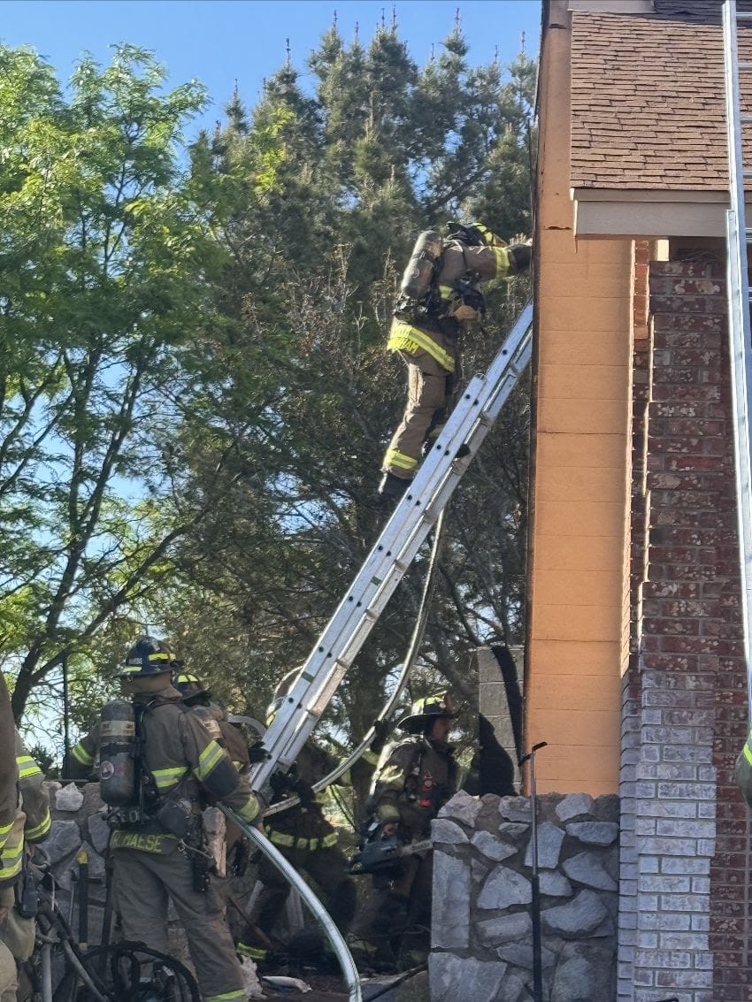 Firefighters working outside a two-story home during a structure fire response on Stagecoach Drive in Las Cruces