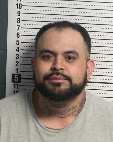 Booking photo of a man identified as Pablo Martinez in front of a height chart.
