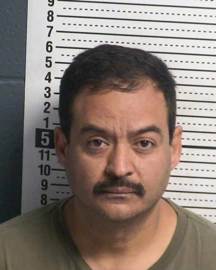 Booking photo of a man identified as Pablo Montoya Martinez in front of a height chart.