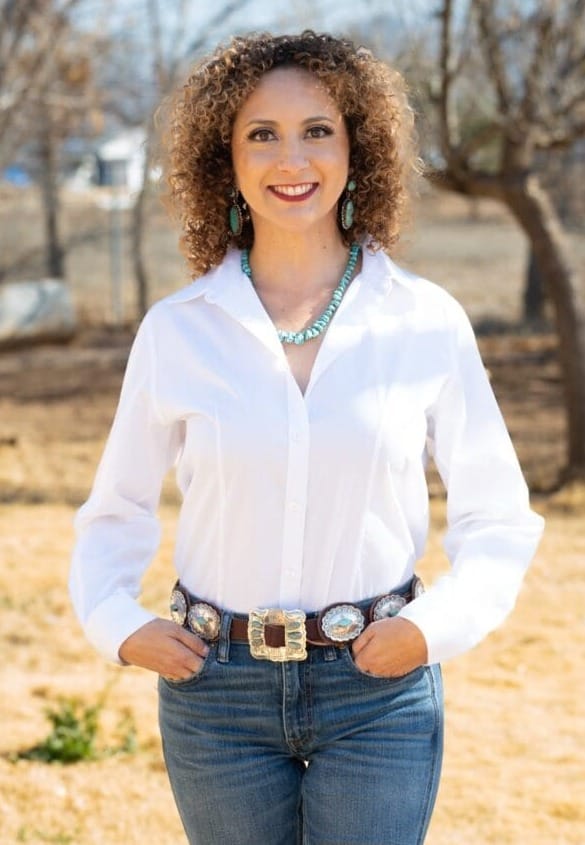 Ramona Martinez stands outdoors wearing a white blouse and turquoise jewelry, smiling in a portrait photo.