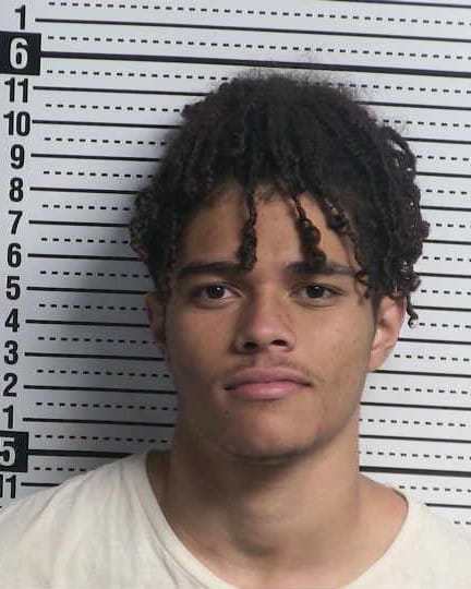 Booking photo of Steven Isaiah Flores against a height chart background.