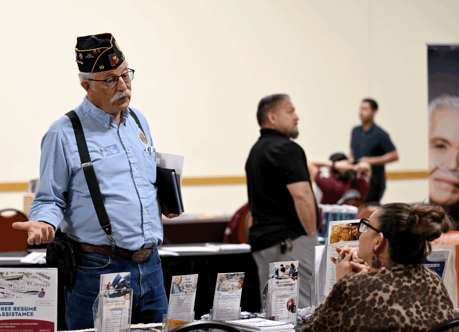 Theron Imlay of American Legion Post 10 speaks with an attendee at the Heroes Hiring Heroes event at the Las Cruces Convention Center.