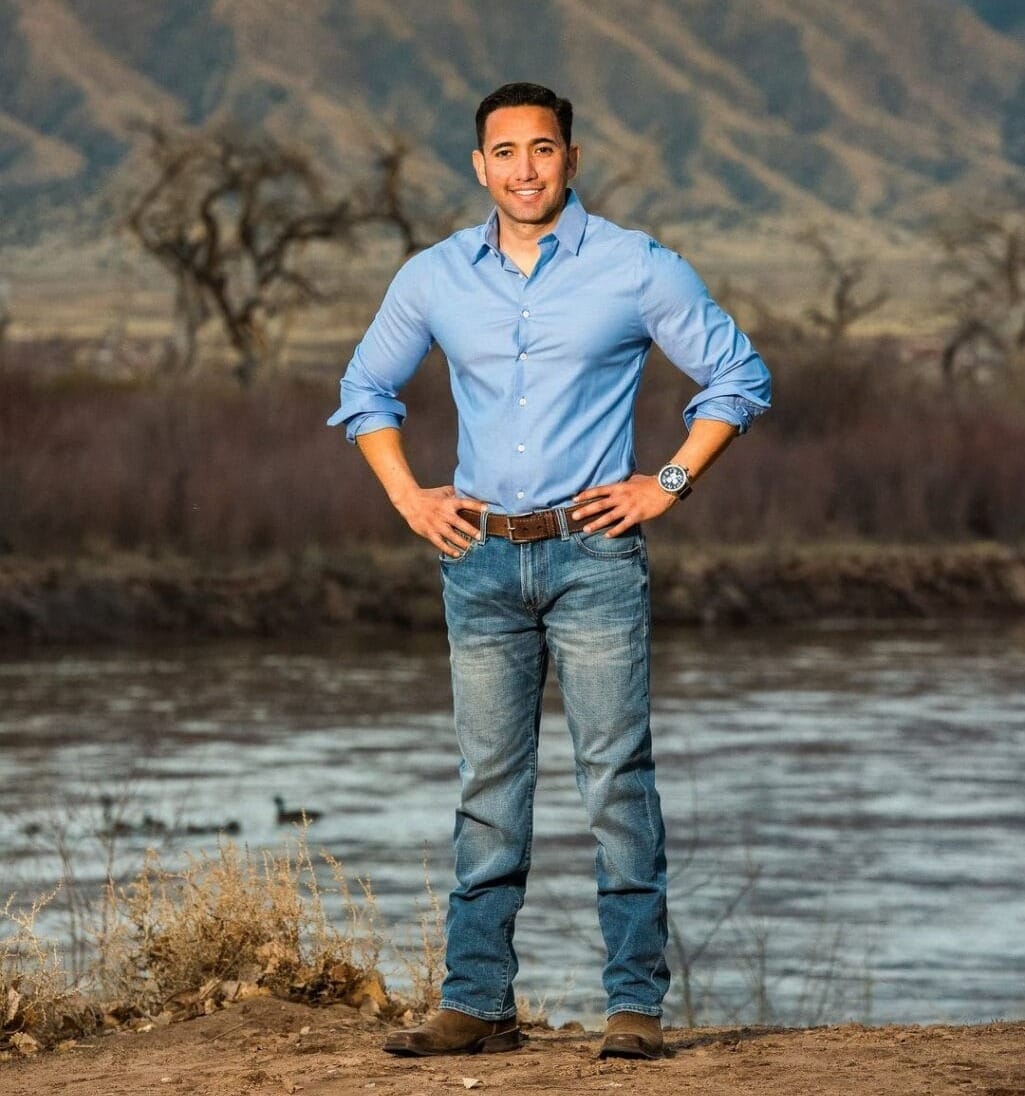 Former Republican congressional candidate Jose Orozco stands outdoors near a river with mountains in the background.