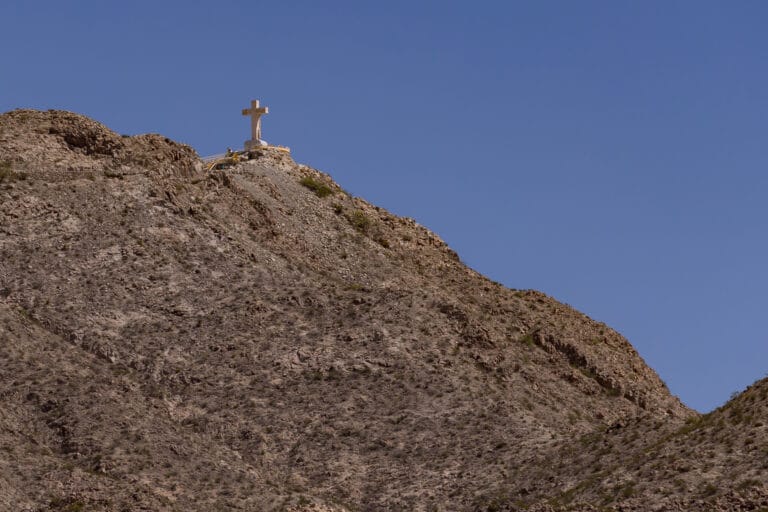 A cross stands atop Mount Cristo Rey overlooking the surrounding desert landscape near Sunland Park.