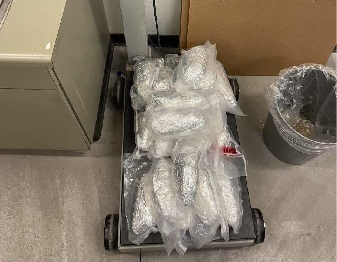 Vacuum-sealed packages of methamphetamine stacked on a scale in an evidence room.