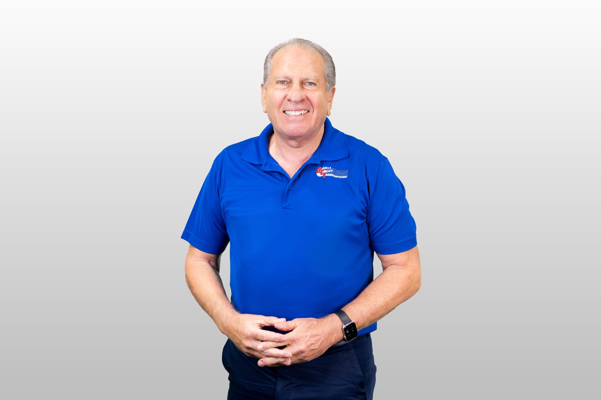 Mesilla Valley Transportation founder Royal Jones poses for a portrait in a blue company shirt.
