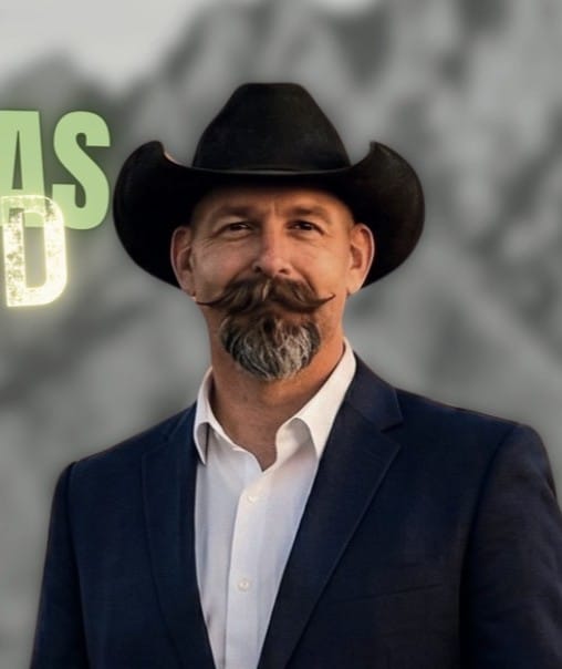 Republican Doña Ana County sheriff candidate Gabriel Baisas poses for a portrait wearing a cowboy hat, white shirt and dark blazer.