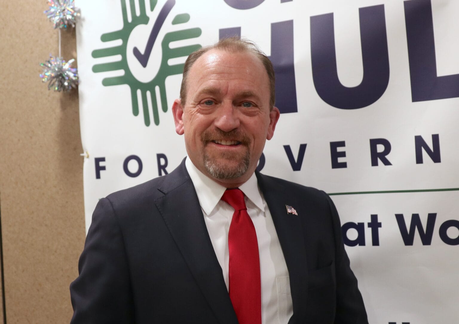 Former Rio Rancho Mayor Gregg Hull poses in front of campaign signage during his Republican campaign for New Mexico governor.