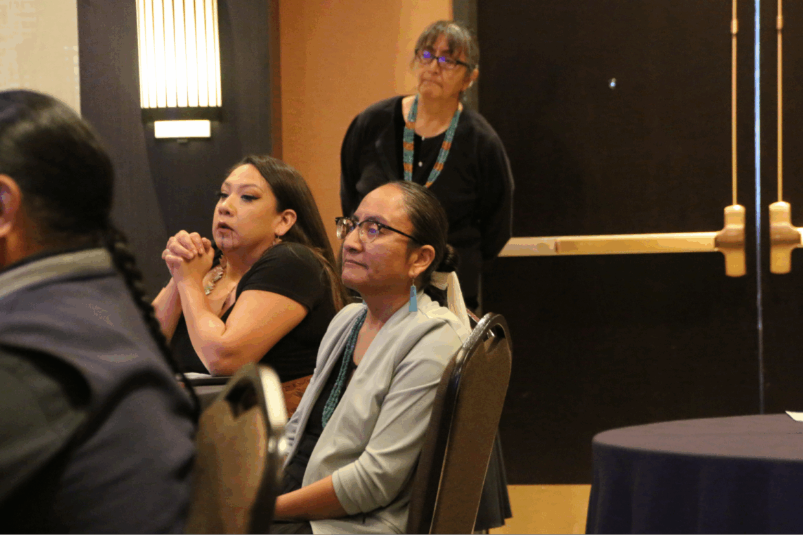 Wilhelmina Yazzie sits and listens during a gathering, with other attendees nearby, as part of the long-running education lawsuit in New Mexico.