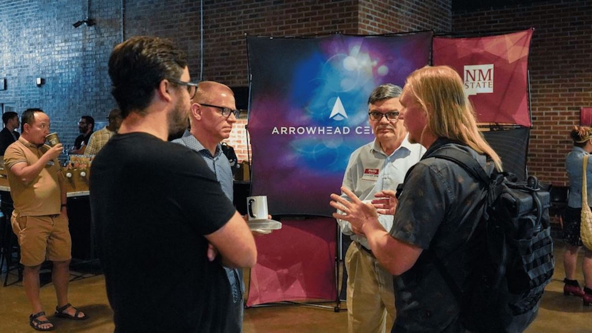 Attendees speak during an Arrowhead Center event at New Mexico State University promoting innovation and entrepreneurship programs.
