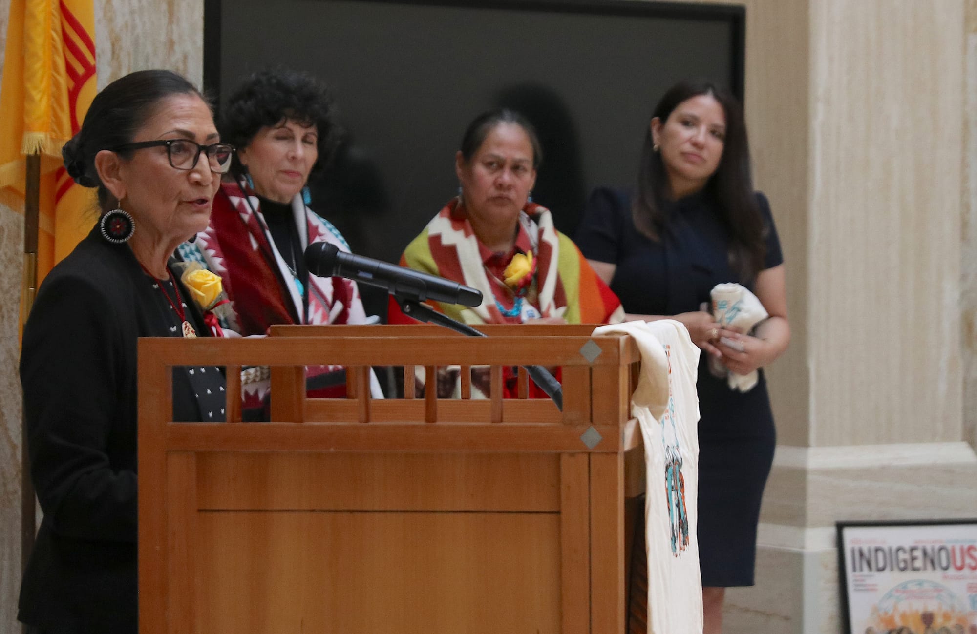 Former Interior Secretary and gubernatorial candidate Deb Haaland speaks at a podium during Indigenous Women’s Day at the New Mexico Roundhouse in Santa Fe.