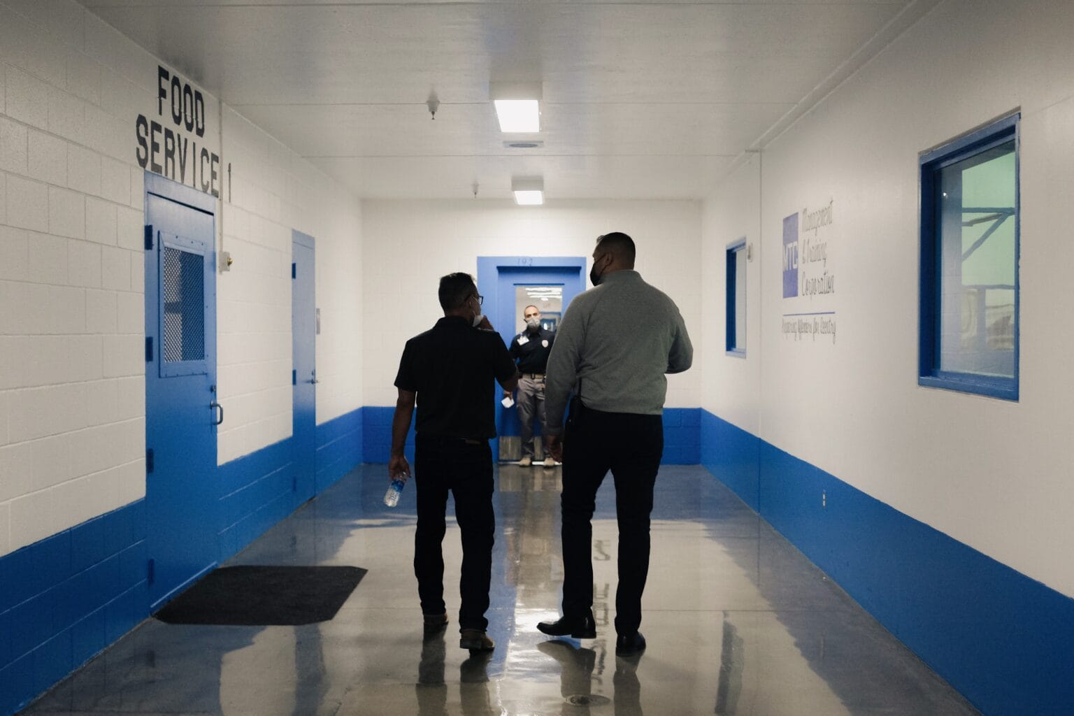 Two people walk through a hallway inside the Otero County Processing Center in southern New Mexico, where federal immigration detainees are housed under contract agreements challenged in a new lawsuit filed by the U.S. Department of Justice.