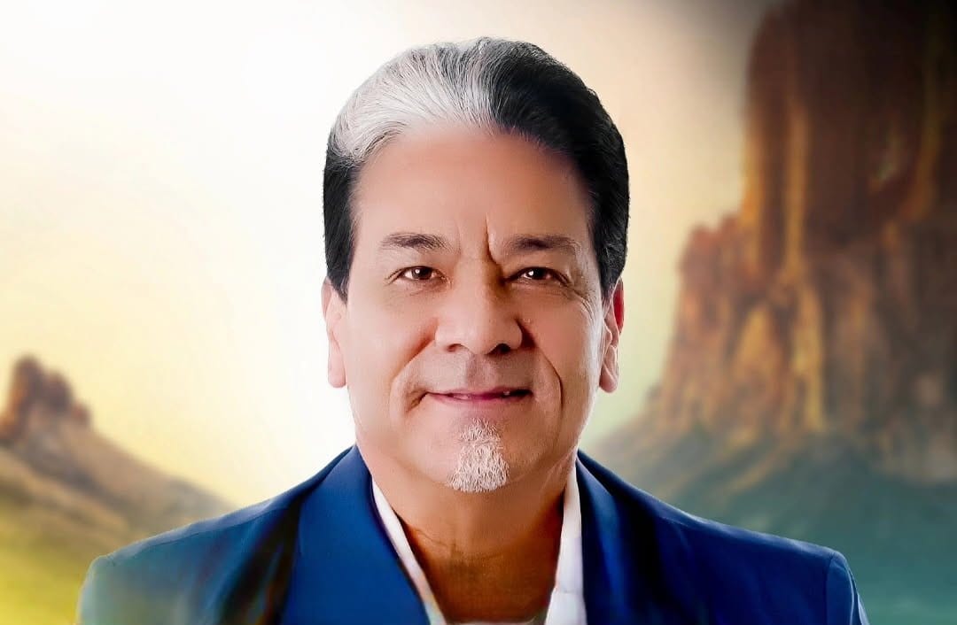 Portrait of Manuel “Manny” Lardizabal in a suit jacket against a stylized desert landscape background.