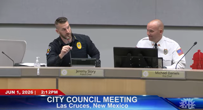 Las Cruces Police Chief Jeremy Story speaks into a microphone during a June 1 City Council meeting, with Fire Chief Michael Daniels seated beside him.