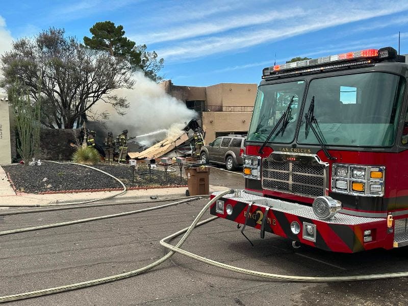 Las Cruces fire engine parked in front of a Fairway Drive residence as firefighters spray water on smoking debris near the garage.