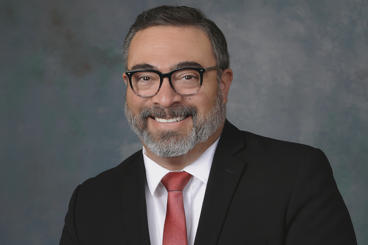 Portrait of State Rep. Raymundo Lara wearing glasses, a dark suit and red tie.
