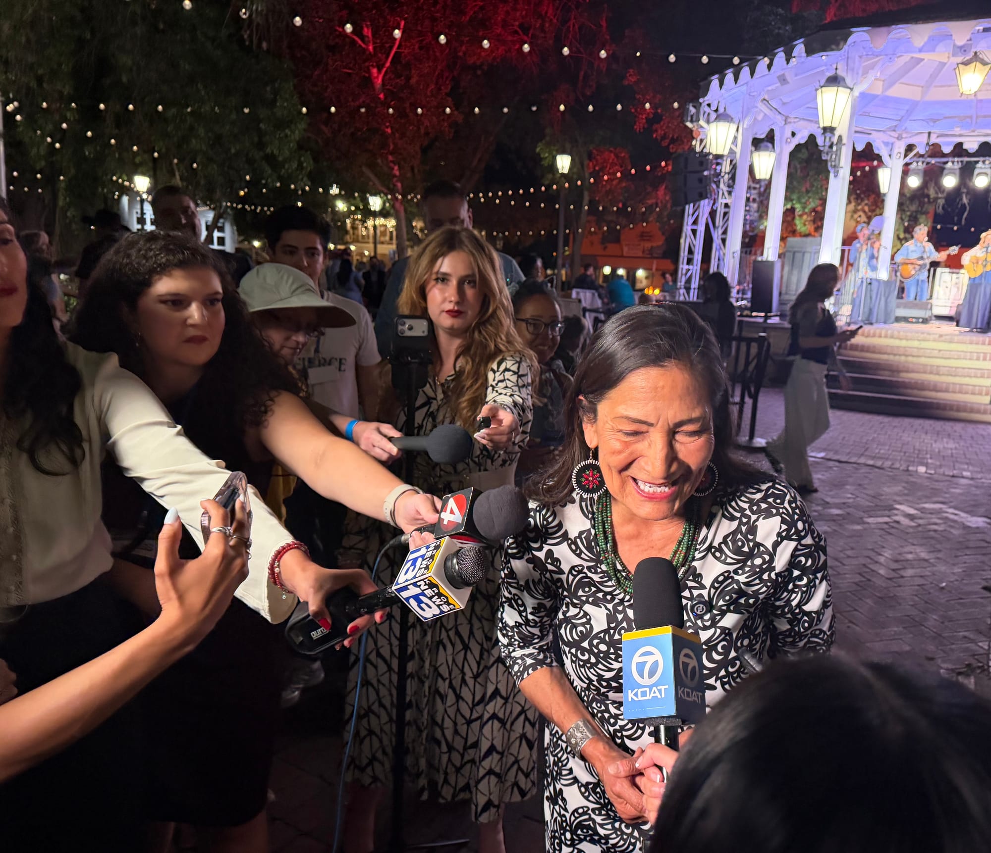 Deb Haaland speaks to reporters after winning the Democratic nomination for New Mexico governor, with microphones extended toward her at an outdoor event.