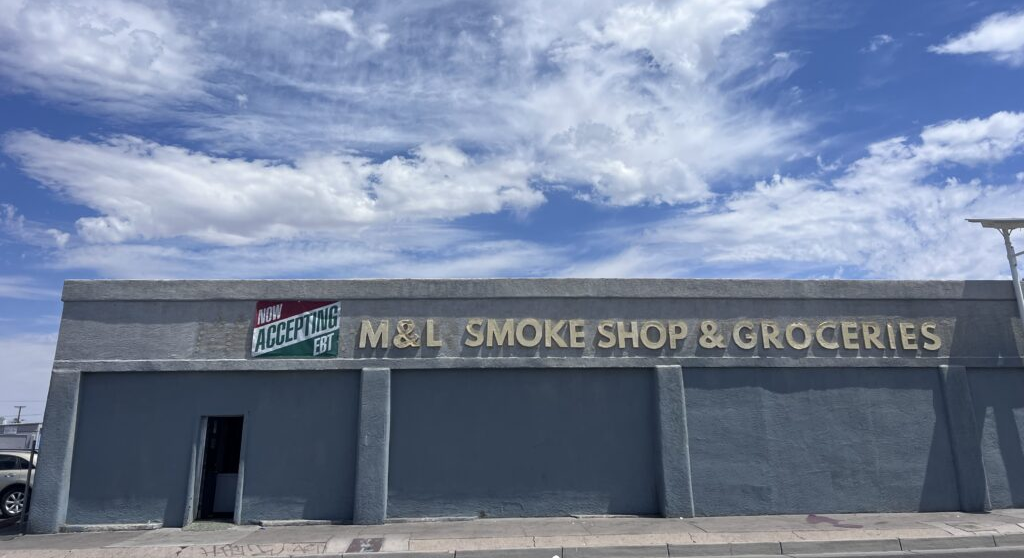 The exterior of M&L Smoke Shop & Groceries in Albuquerque is shown with a sign advertising EBT acceptance.