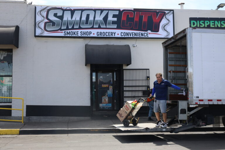 A worker unloads groceries from a delivery truck outside Smoke City in Albuquerque’s International District.