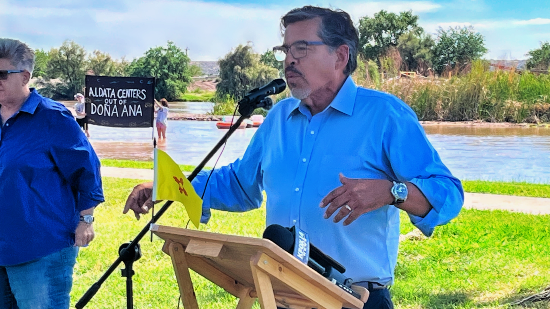 Sen. Joseph Cervantes speaks at a microphone near the Rio Grande during a Project Jupiter press conference.