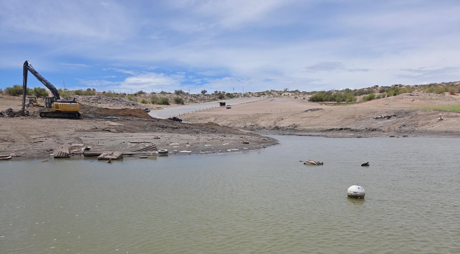 A long-reach excavator removes debris along the exposed shoreline near the Marina del Sur boat ramp at Elephant Butte Lake.