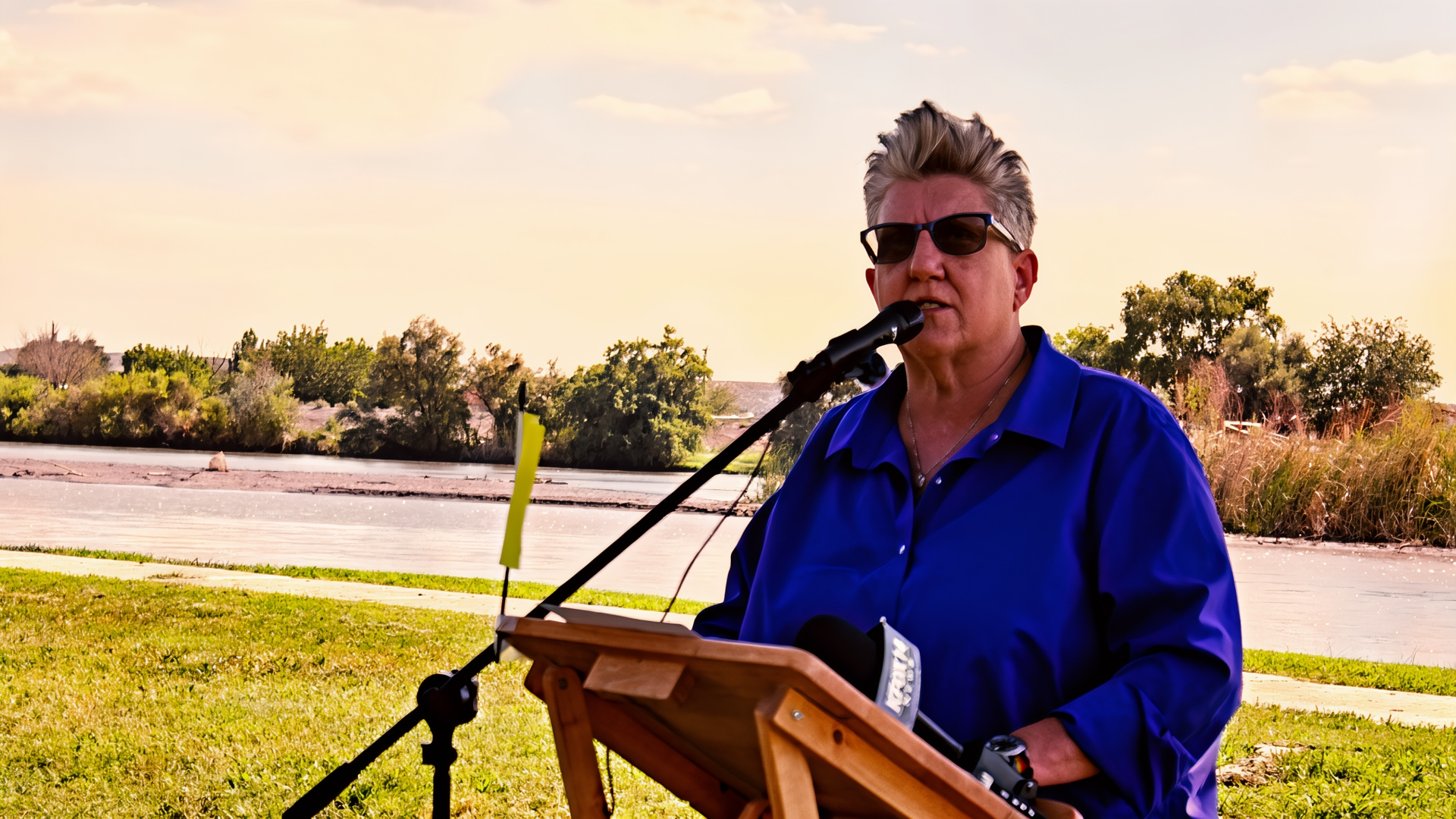 Sen. Carrie Hamblen speaks at a microphone near the Rio Grande at La Llorona Park.